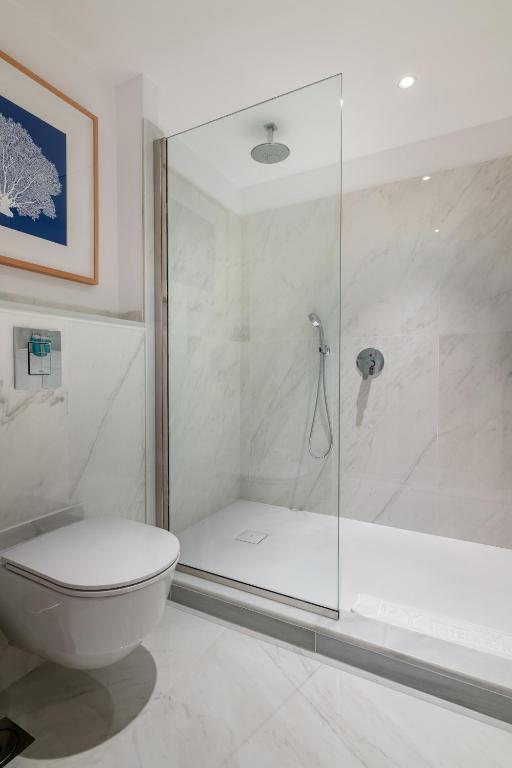 a bathroom with a glass shower and a toilet at Hotel Fariones in Puerto del Carmen