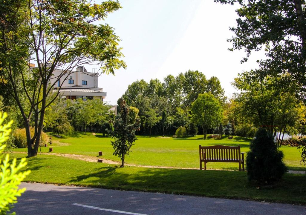 a park bench in a park with a building in the background at Caro Hotel in Bucharest