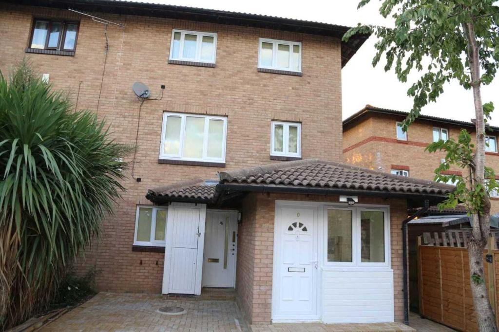 a brick house with white doors and a garage at Budget 4-Bedrooms In Thamesmead in London