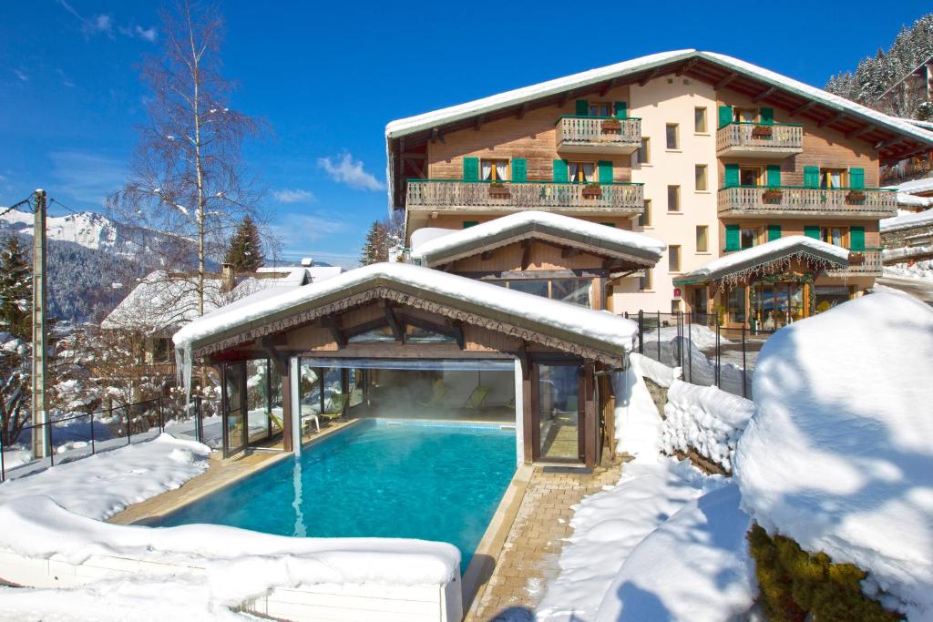 a house with a swimming pool in the snow at L'Hermine Blanche in Morzine