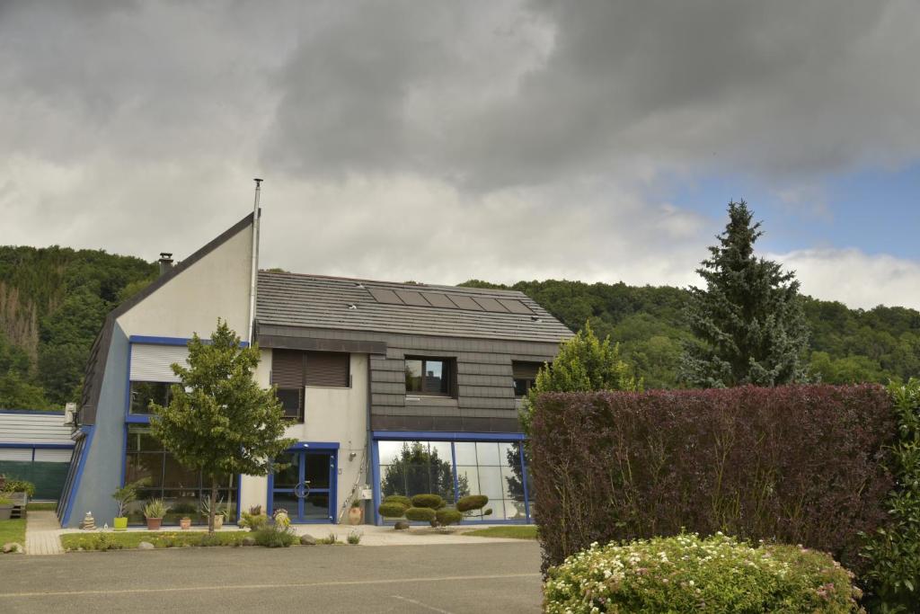 un bâtiment dans un parking arboré dans l'établissement Gite Les cigognes de la Doller, à Sentheim