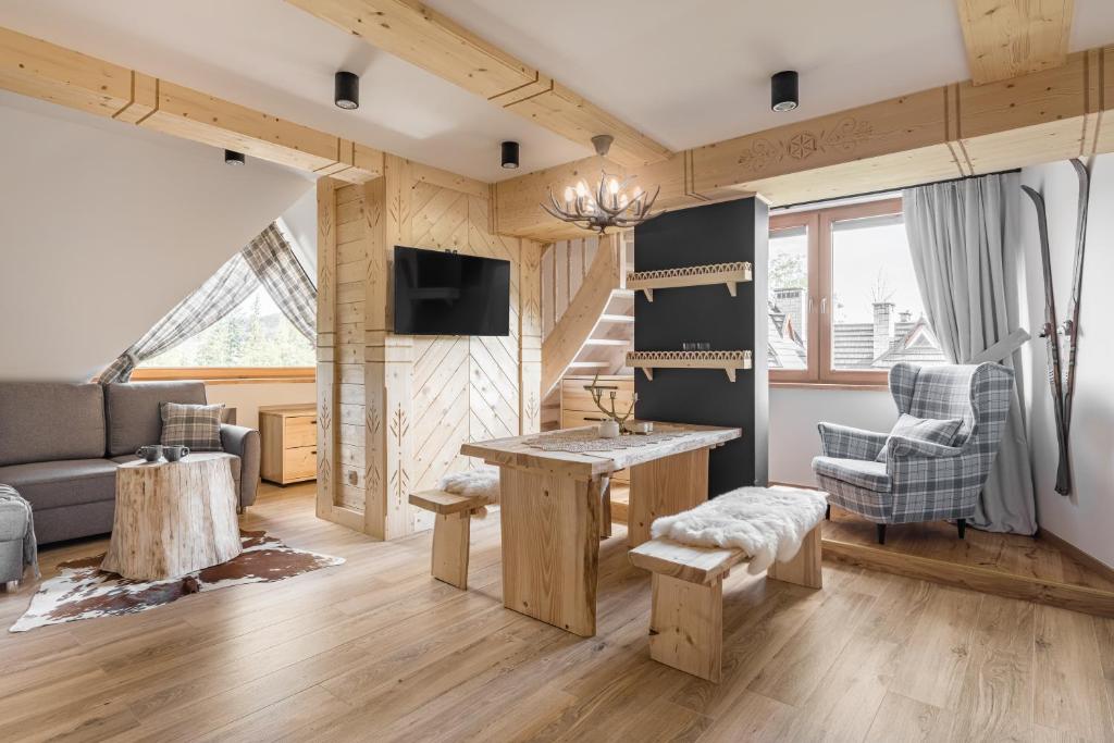ein Wohnzimmer mit einem Tisch und einem Sofa in der Unterkunft Apartamenty w Chmurach in Kościelisko