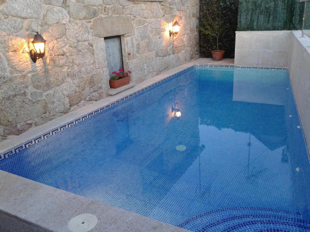 een groot zwembad met blauw water bij O Lar de Sara in Pontevedra