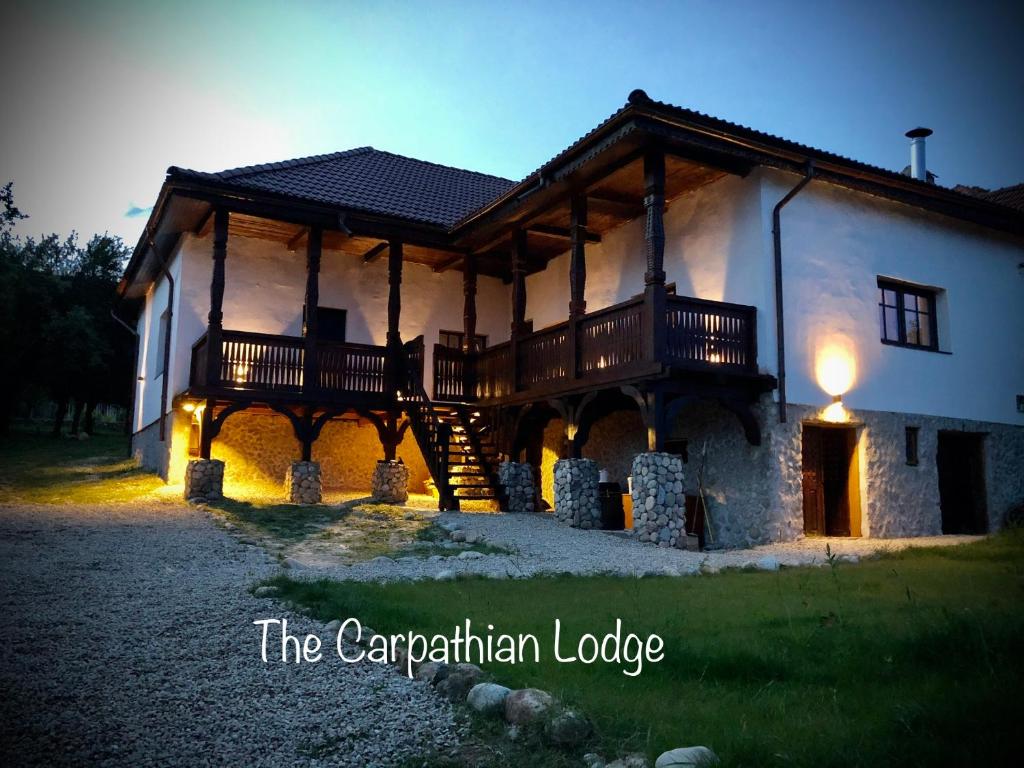 a large building with a porch and a deck at The Carpathian Lodge in Runcu