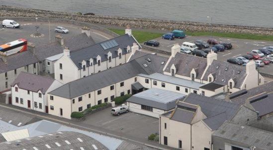 una vista aérea de un gran edificio blanco con aparcamiento en Ayre Hotel & Ayre Apartments, en Kirkwall