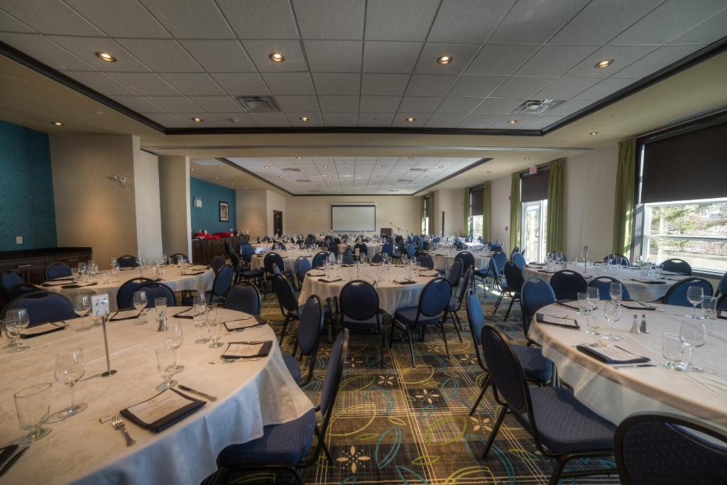 a banquet hall with tables and chairs and a screen at Holiday Inn Express & Suites Spruce Grove - Stony Plain by IHG in Spruce Grove