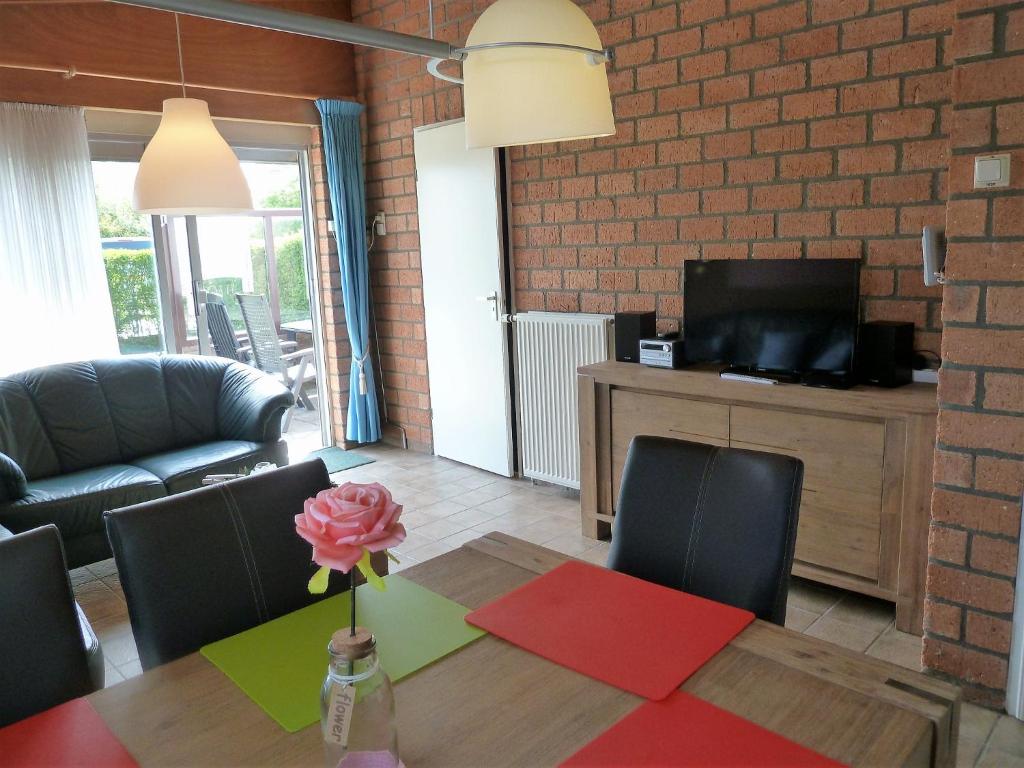 ein Wohnzimmer mit einem Tisch mit einer Blume in einer Vase in der Unterkunft Vacation home Zwaantje #BL66 in Callantsoog