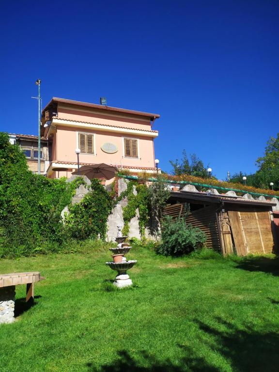 una casa in un giardino con un bagno di uccelli nell'erba di B&B Francesca a Zagarise