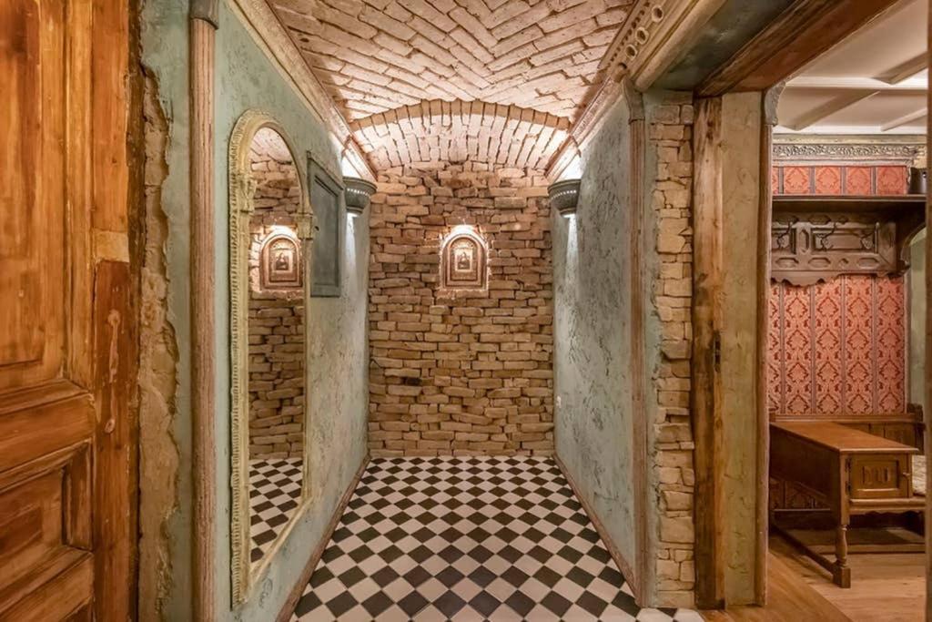 a hallway with a brick wall and a checkered floor at Beautiful one bedroom apartment in Vilnius old town in Vilnius