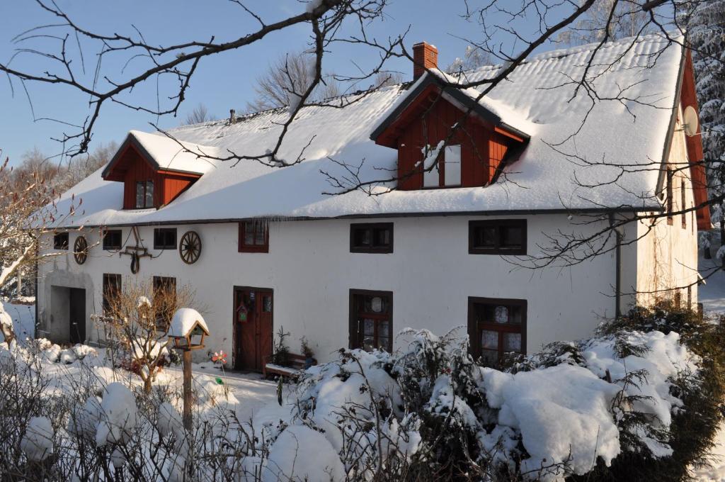 Biały dom z pokrytym śniegiem dachem w obiekcie Czarnotka w mieście Mirsk