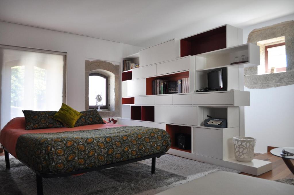 a living room with a couch and a book shelf at Casa do Passadiço in Macieira de Sarnes