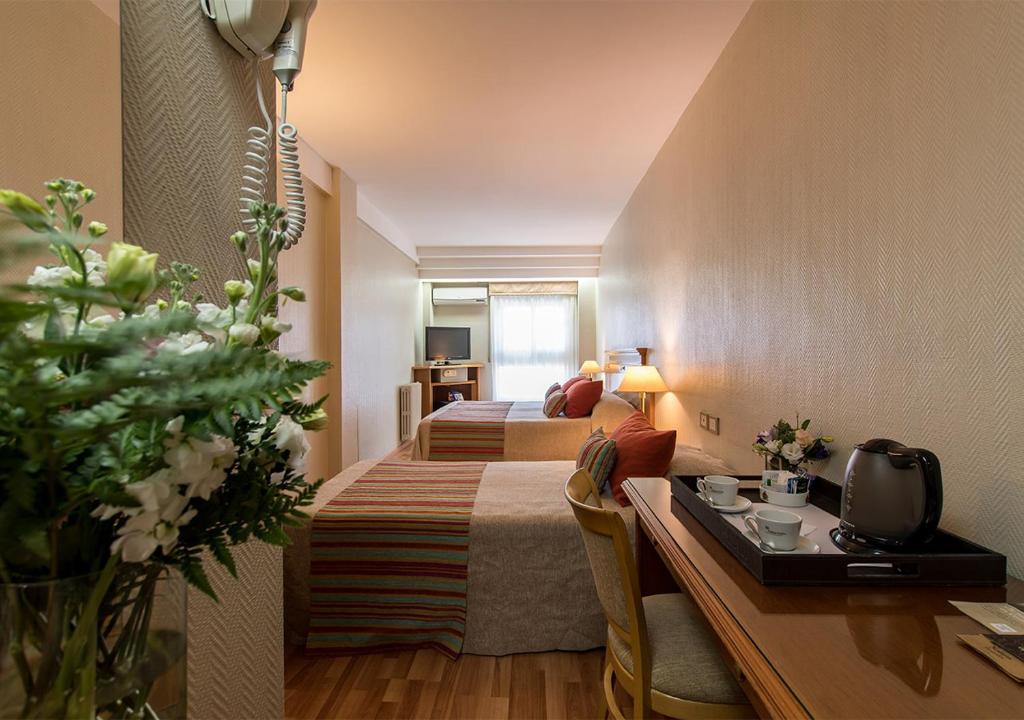 una camera d'albergo con 2 letti e una scrivania di Hotel Solans Riviera a Rosario