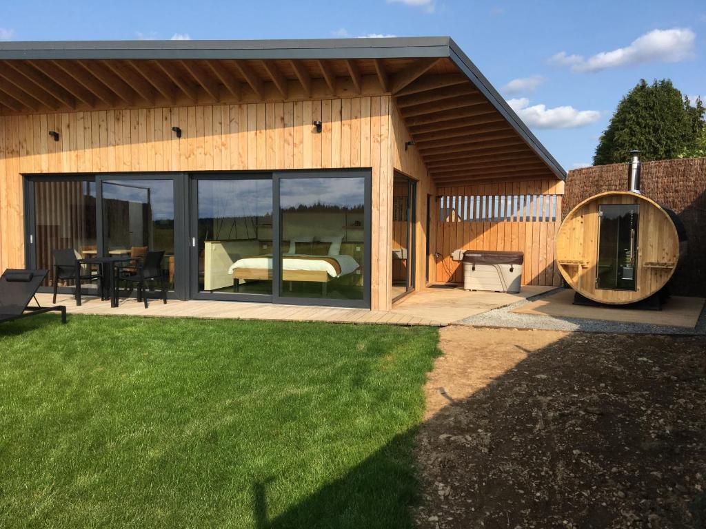 a house with a bedroom and a patio at Beau Réveil nature & wellness - gite 1 in Manhay