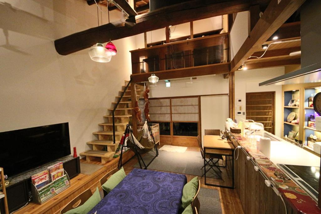 a living room with a staircase and a table and chairs at Nishijin no Sato 西陣之郷 -100 yrs Smart & Sustainable AI Arthouse with 10Gbps wifi - in Kyoto