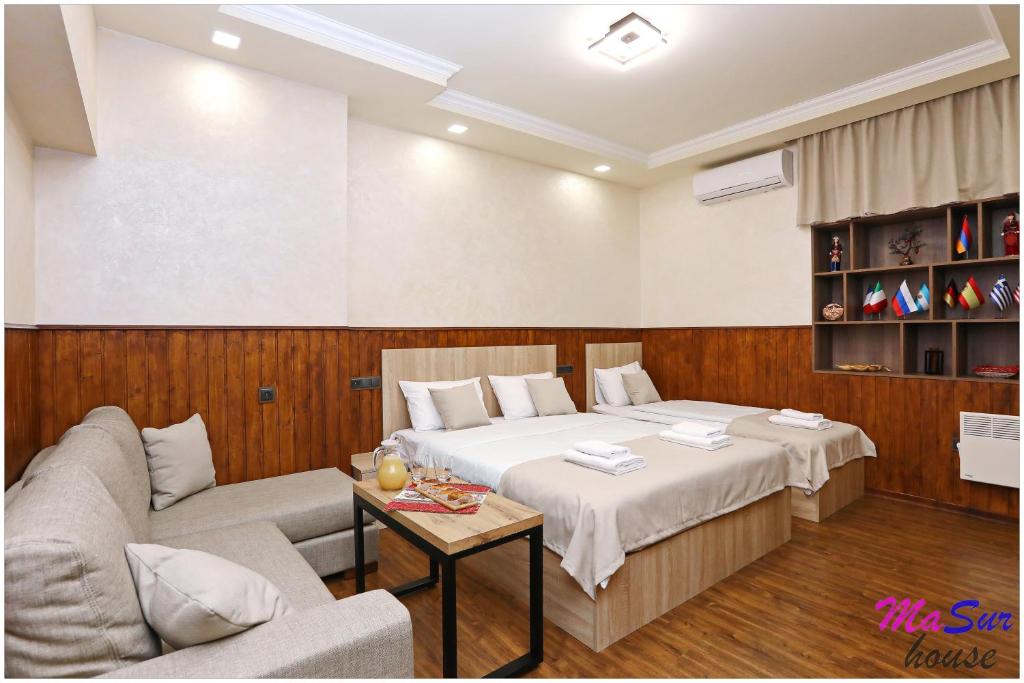 a bedroom with a bed and a couch and a table at Masur House and Tours in Yerevan