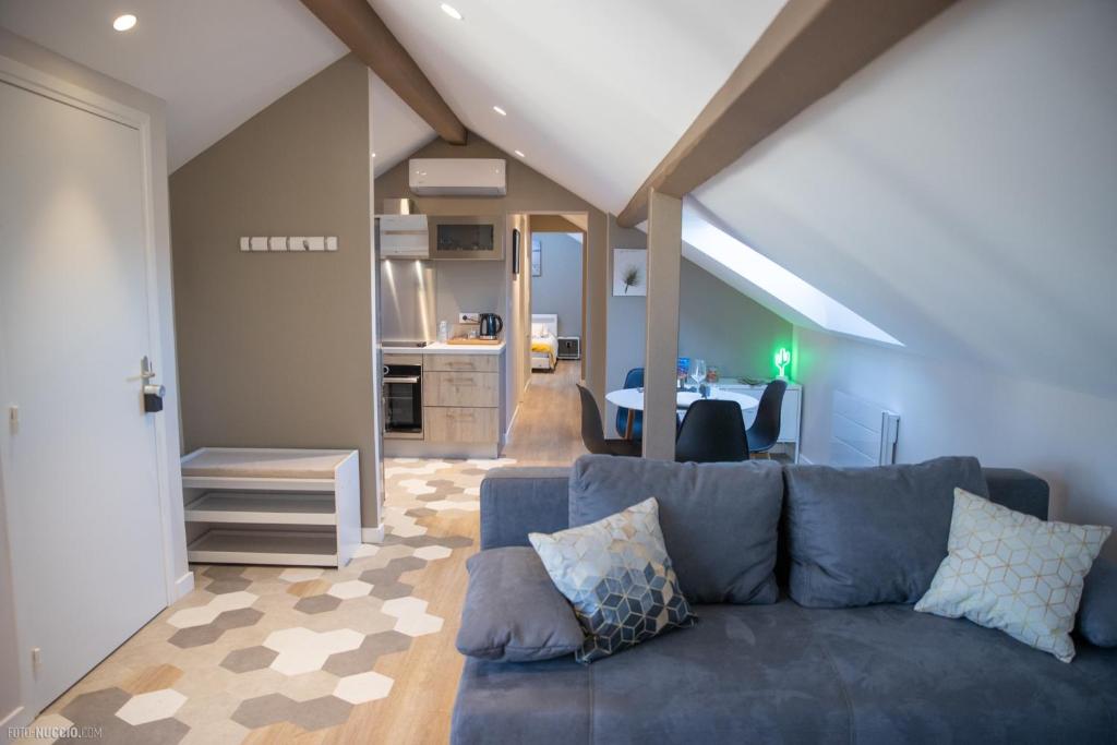 a living room with a blue couch and a kitchen at Modern Living in Huningue