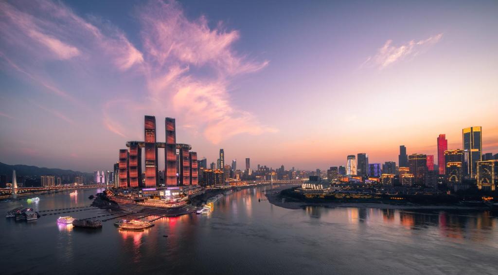 InterContinental Chongqing Raffles City, an IHG Hotel في تشونغتشينغ: اطلالة على مدينة بها نهر ومباني
