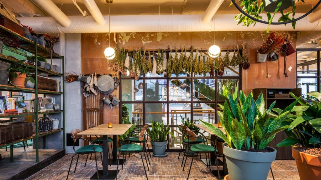 a restaurant with plants and a table and chairs at Hotel Indigo Brussels - City, an IHG Hotel in Brussels