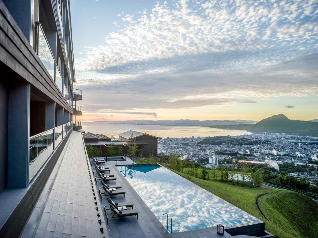 a view from the balcony of a house with a swimming pool at ANA InterContinental Beppu Resort & Spa by IHG in Beppu