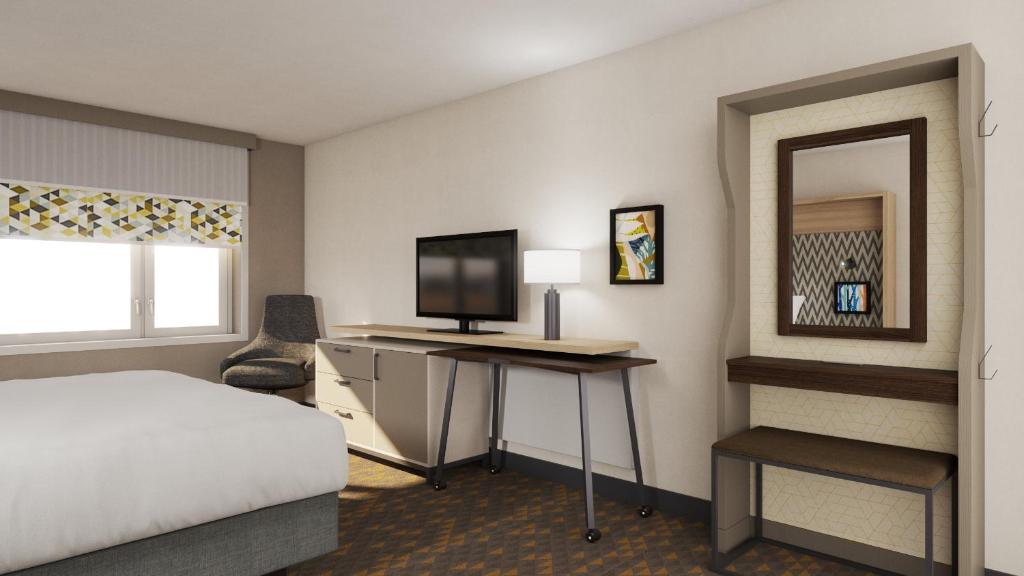 シカゴにあるHoliday Inn Chicago Midway Airport S, an IHG hotelのベッドルーム1室(ベッド1台、デスク、テレビ付)