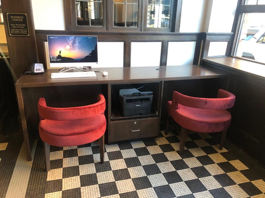 a desk with a computer and two red chairs at Hotel Indigo Spokane Downtown by IHG in Spokane