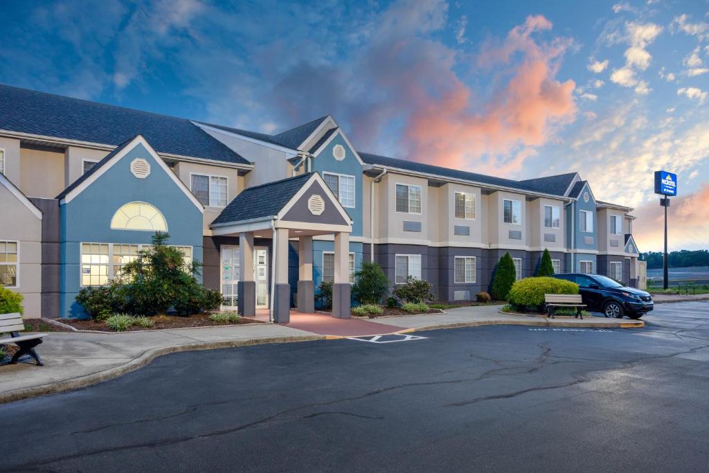 un grand bâtiment avec une voiture garée dans un parking dans l'établissement Microtel Inn & Suites by Wyndham Burlington, à Burlington