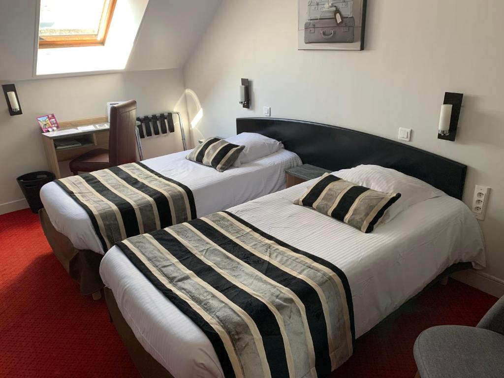 Postel nebo postele na pokoji v ubytování Hôtel Le Bayeux