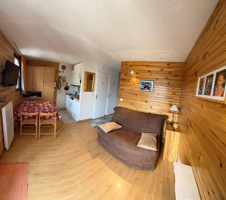 ein Wohnzimmer mit einem Sofa und einem Tisch in der Unterkunft Boost Your Immo Les Airelles Risoul 375 in Risoul