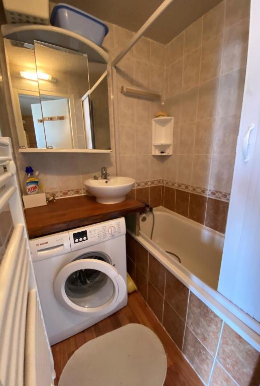 a bathroom with a washing machine and a sink at Boost Your Immo Les Airelles Risoul 375 in Risoul