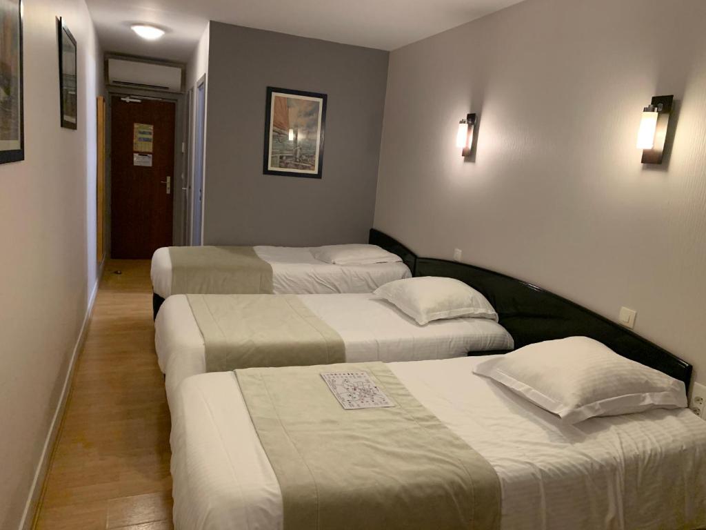 Postel nebo postele na pokoji v ubytování Hôtel Le Bayeux