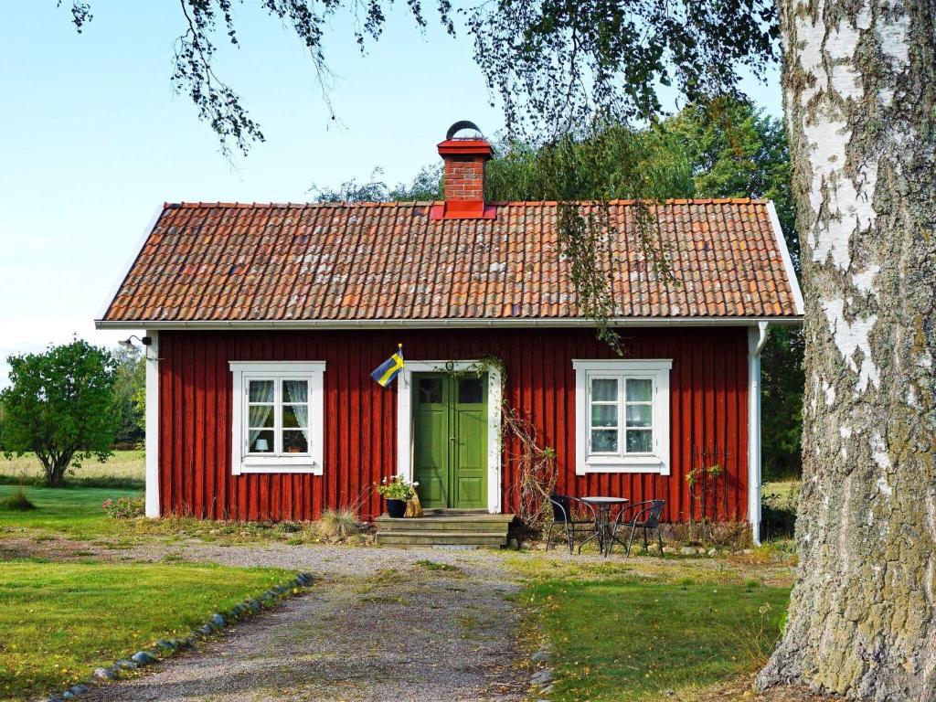 uma casa vermelha e branca com uma porta verde em Holiday home Vrena em Vrena