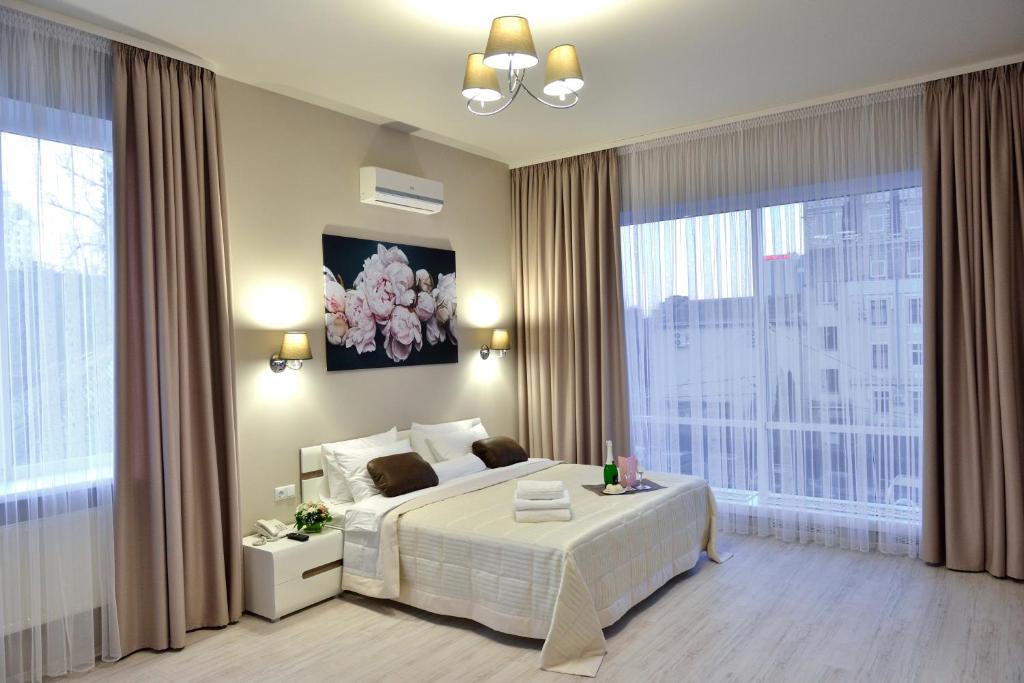 1 dormitorio con cama blanca y ventana grande en Gosudar Hotel, en Kropyvnytskyi