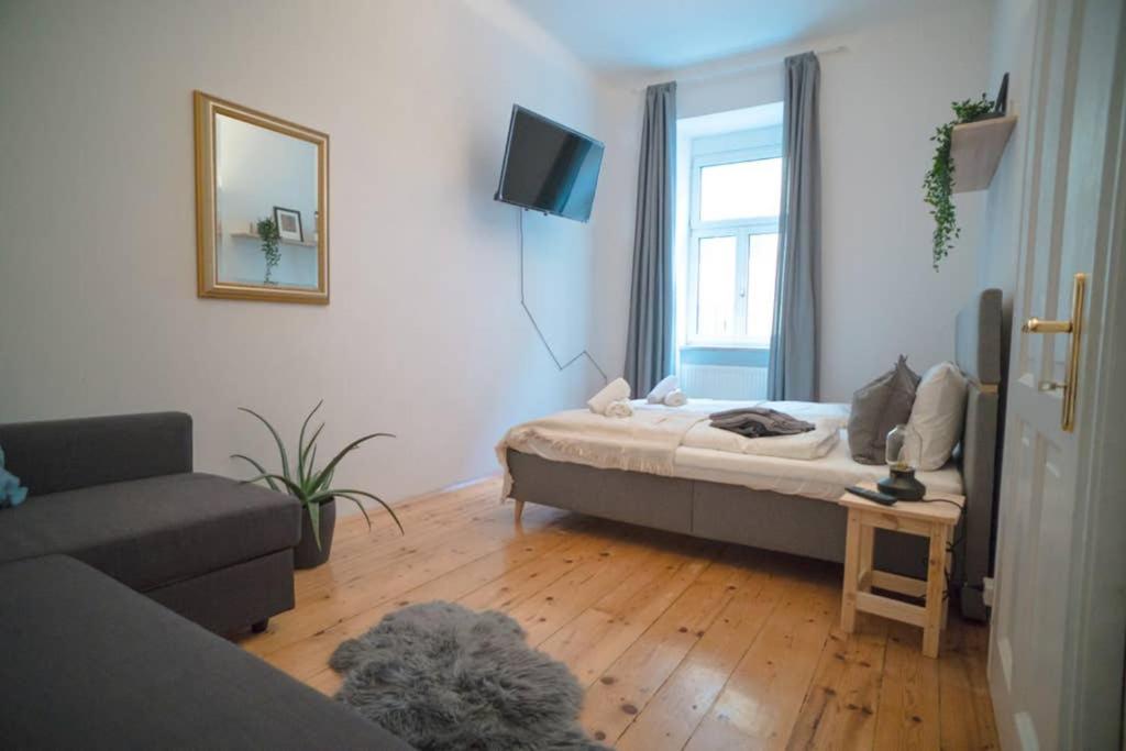 uma sala de estar com uma cama e uma janela em Cosy and Spacious Apartment in the heart of Innsbruck em Innsbruck