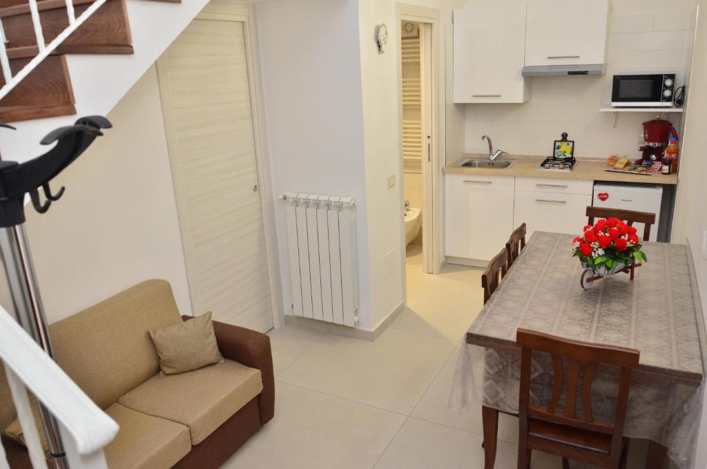 uma cozinha e sala de estar com mesa e cadeiras em Happy House Pompei em Pompeia