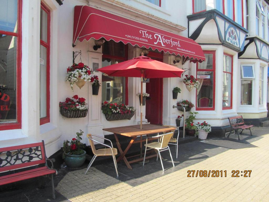 a table with an umbrella outside of a building at The Aberford in Blackpool