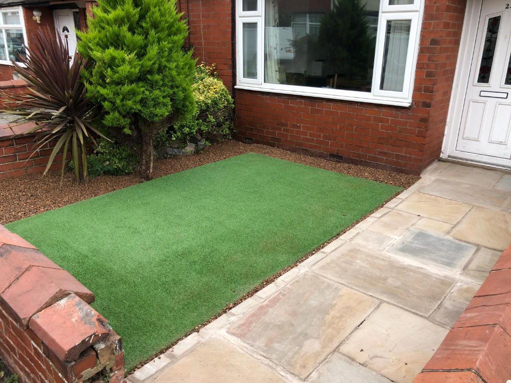 a patch of green grass in front of a house at Beautiful house in a perfect location in Saint Annes on the Sea