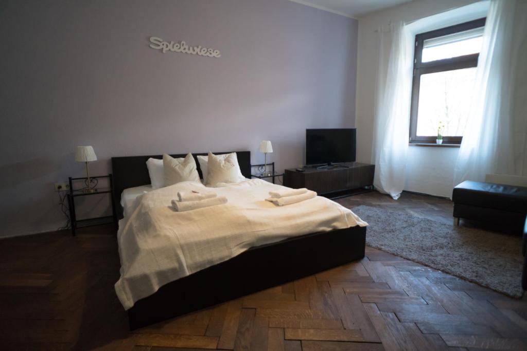 インスブルックにあるGemütliche Altbauwohnung im Zentrumのベッドルーム(大型ベッド1台、テレビ付)