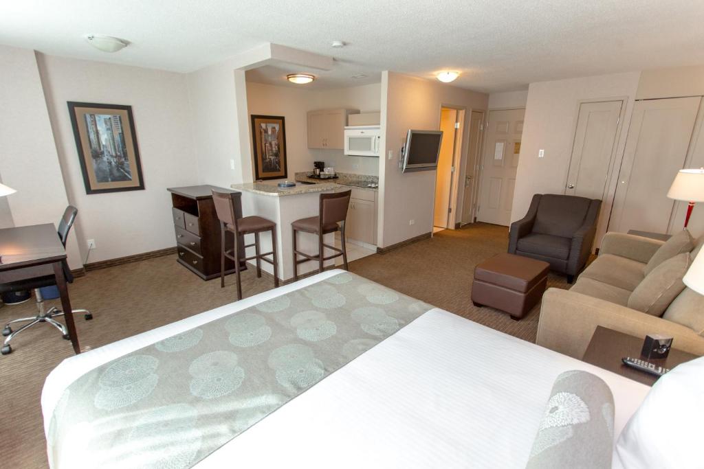 a hotel room with a bed and a living room at Campus Tower Suite Hotel in Edmonton