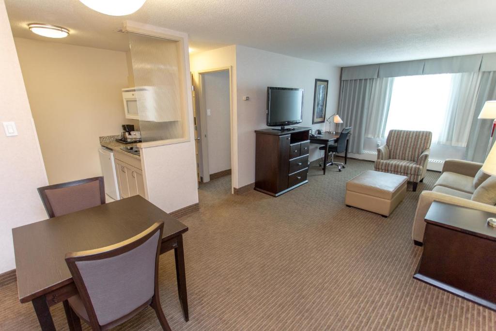 a living room filled with furniture and a kitchen at Campus Tower Suite Hotel in Edmonton