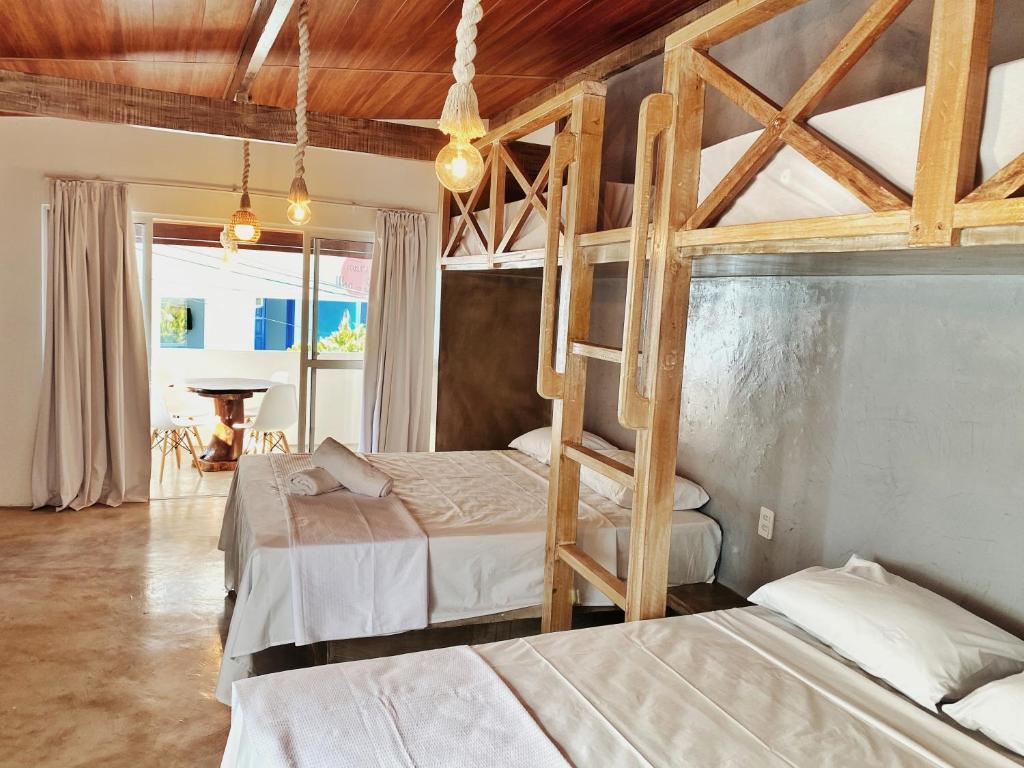 a bedroom with two bunk beds and a piano at Pousada Primeira Praia Suítes in Morro de São Paulo