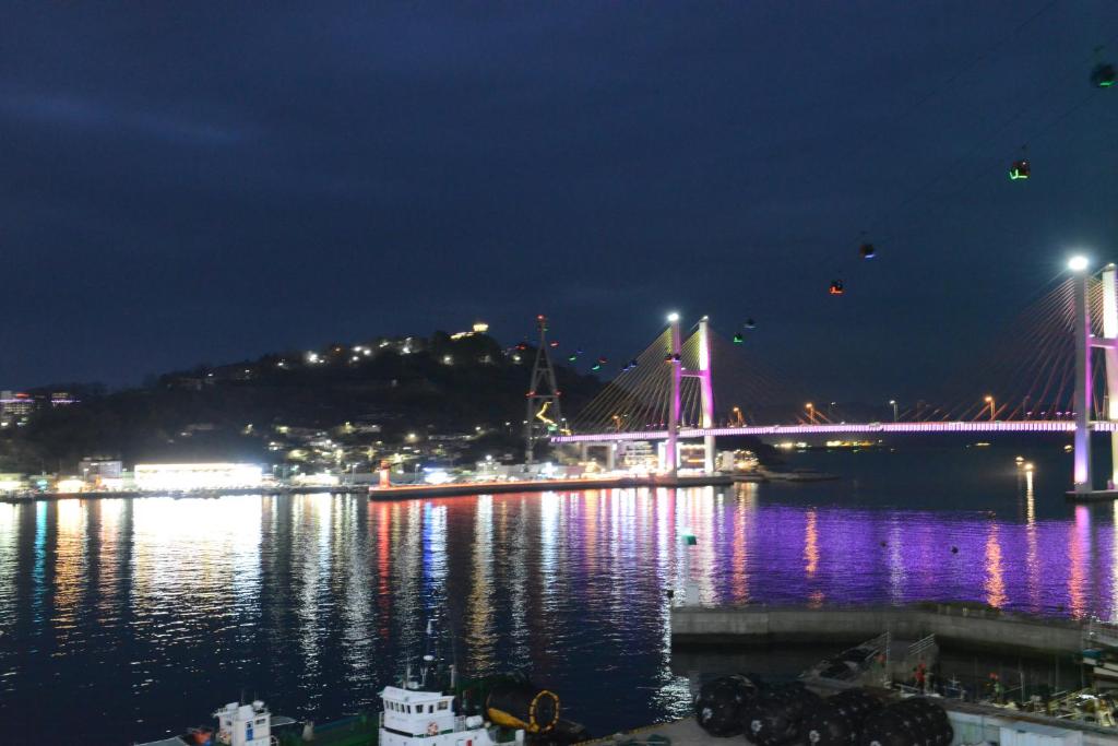 a bridge over a body of water at night at Lium Spa Hostel in Yeosu