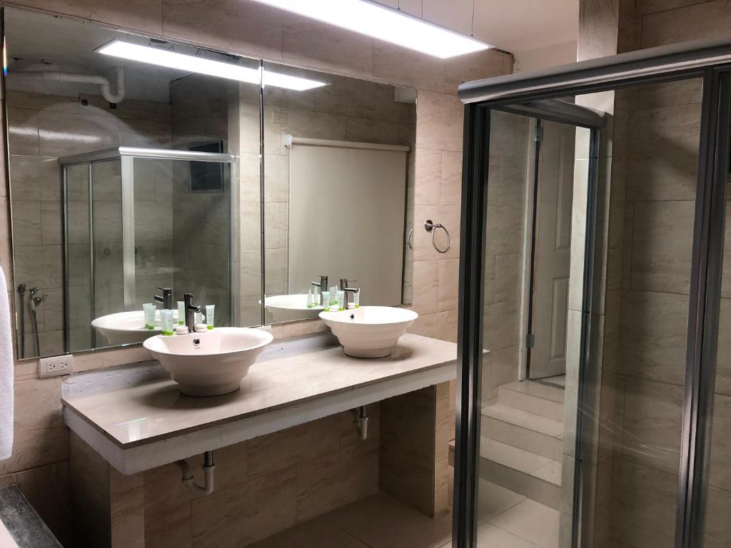 een badkamer met 2 wastafels en een douche bij Hotel HSR in Panama-Stad