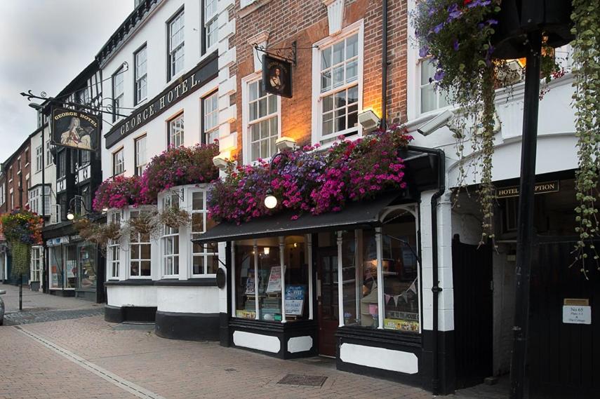 a building with flower boxes on it on a street at George Hotel Wetherspoon in Bewdley
