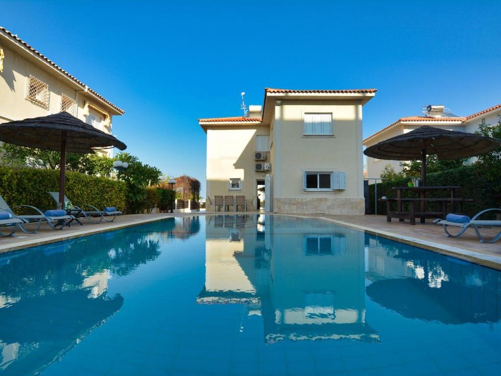 a swimming pool in front of a house at Villa Oforo Selene - Stunning 4 Bedroom Villa - By Fig Tree Bay Beach - Sea Views in Protaras