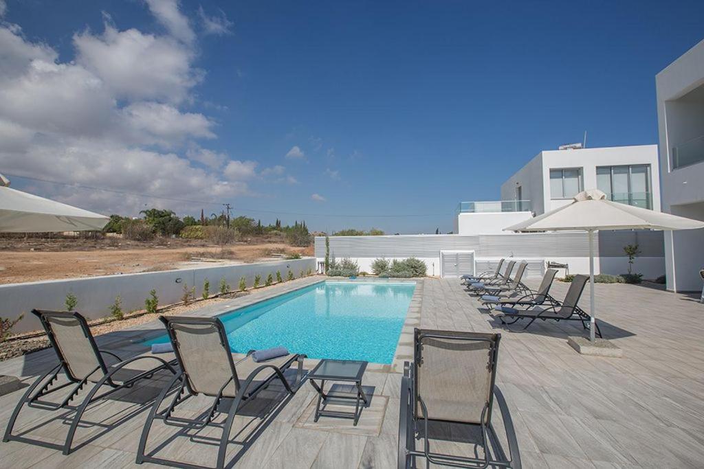 - un groupe de chaises et une piscine dans l'établissement Villa Ochosto Loux - Fabulous 5 Bedroom Protaras Villa with Private Pool - Close to the Beach, à Protaras