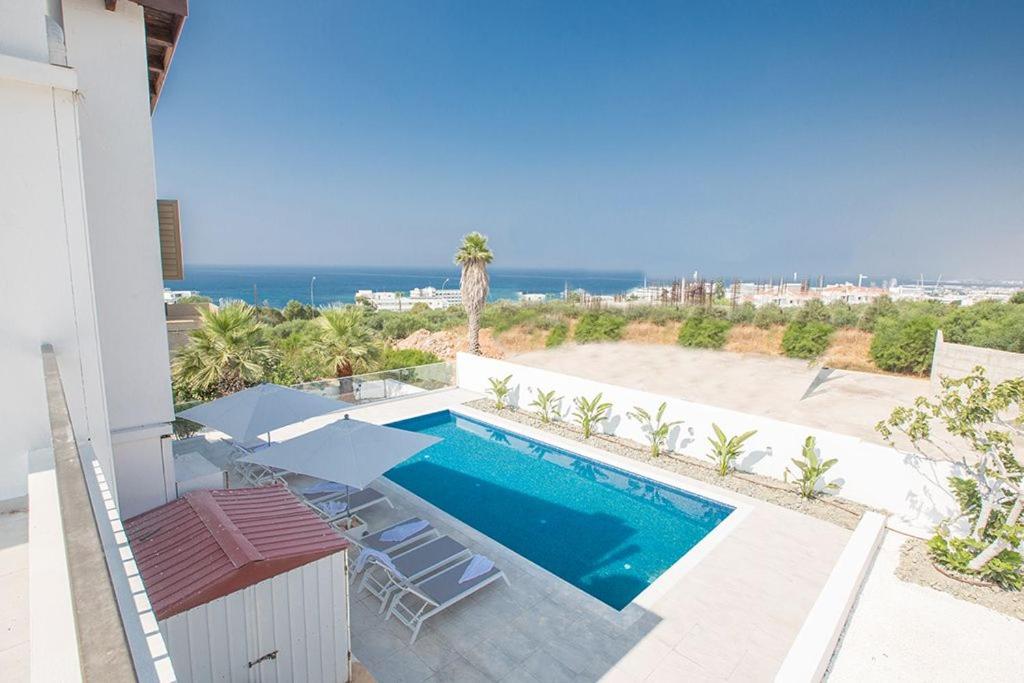 uma piscina com cadeiras e vista para o oceano em Villa Nepou - Beautiful 4 Bedroom Villa - Located in Ayia Napa Villa With Private Pool em Agia Napa