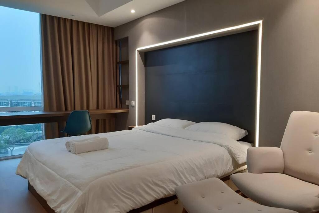 een slaapkamer met een groot bed met een groot zwart hoofdeinde bij U Residence 2 Studio Apartment POOL VIEW in Tangerang