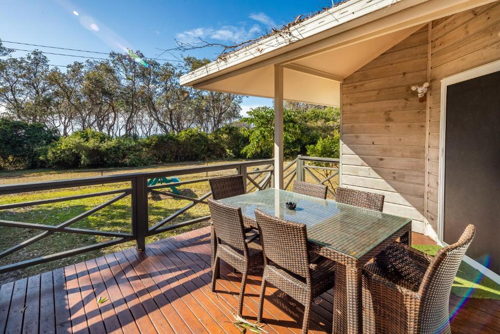 a patio with a table and chairs on a deck at Ingenia Holidays Bonny Hills in Bonny Hills