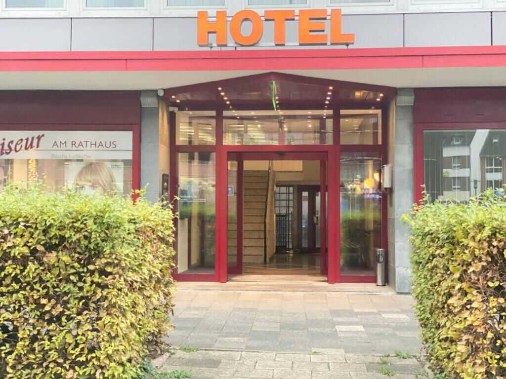 uma entrada para um hotel com uma porta vermelha em Hotel am Rathaus em Flensburg