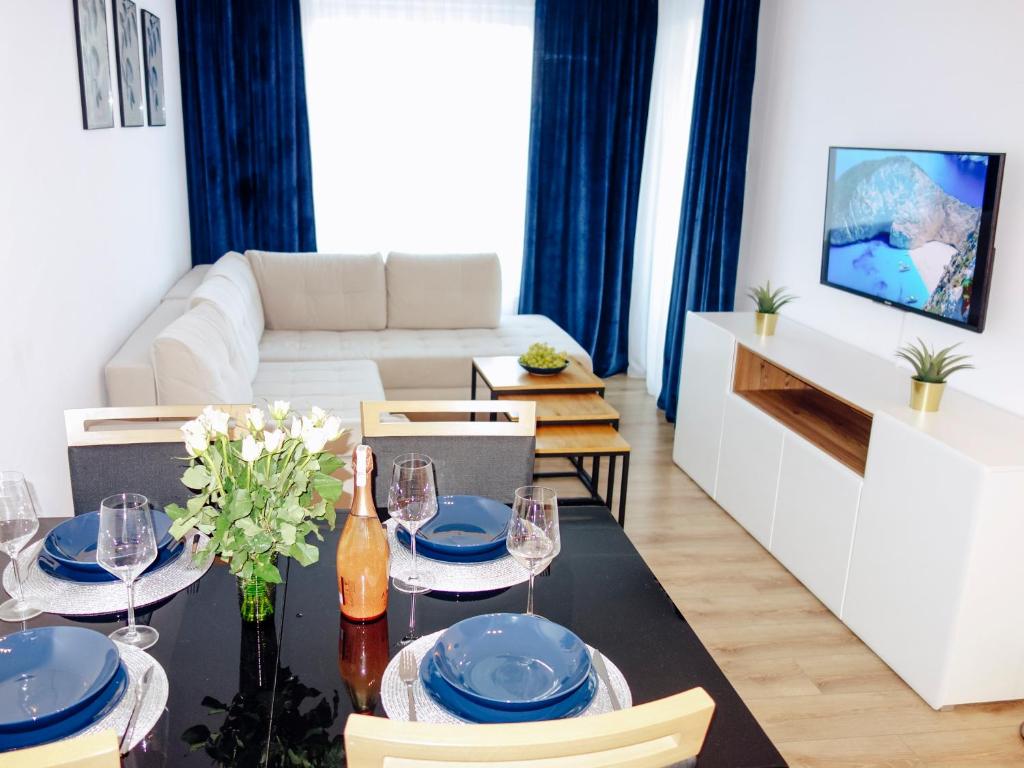 - un salon avec une table à manger agrémentée de plats bleus dans l'établissement Sun4You Polanki Park, à Kołobrzeg